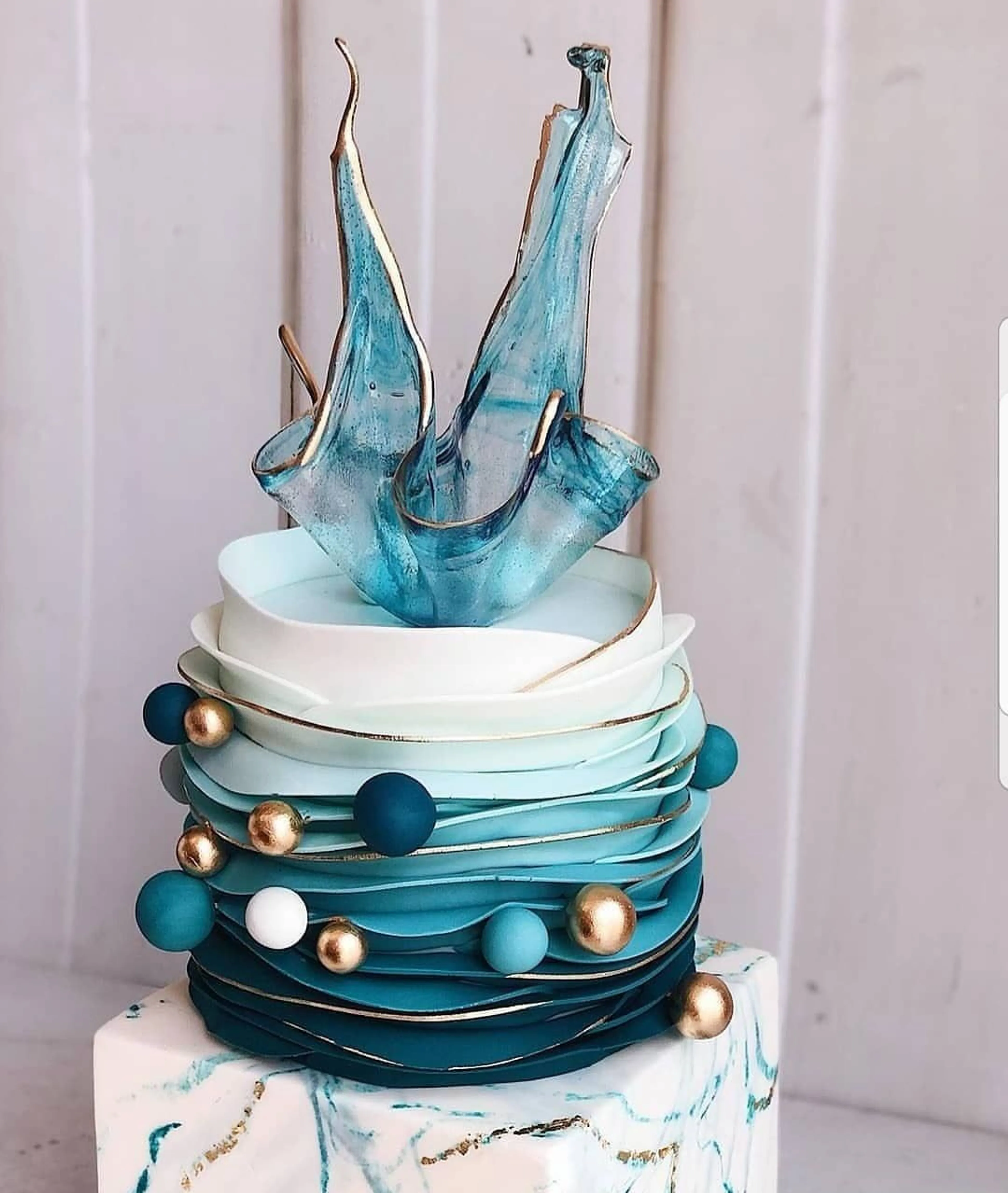 Modern düğün pastası şeffaf izomalt şeker detayları, içinde kurutulmuş çiçekler ve altın varak parçaları, stüdyo ışığı altında kristal gibi parlayan yüzey