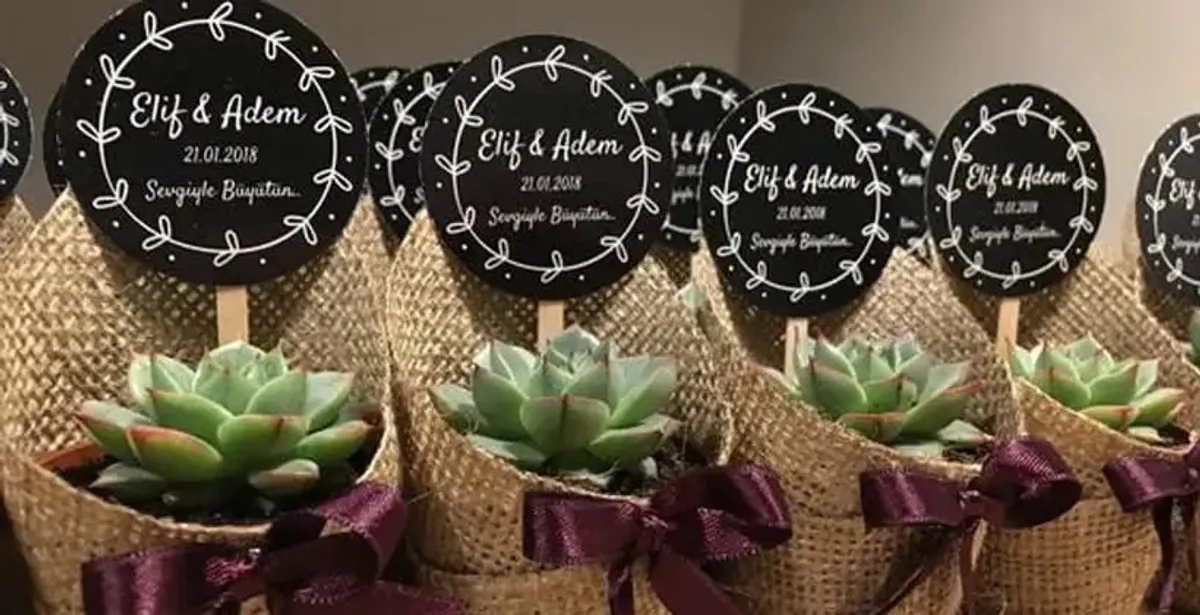 Özel etiketli beyaz mini mumlar, altın rengi kapak ve çift isimli minimal tasarım detaylarıyla lüks düğün hatırası sunum konsepti