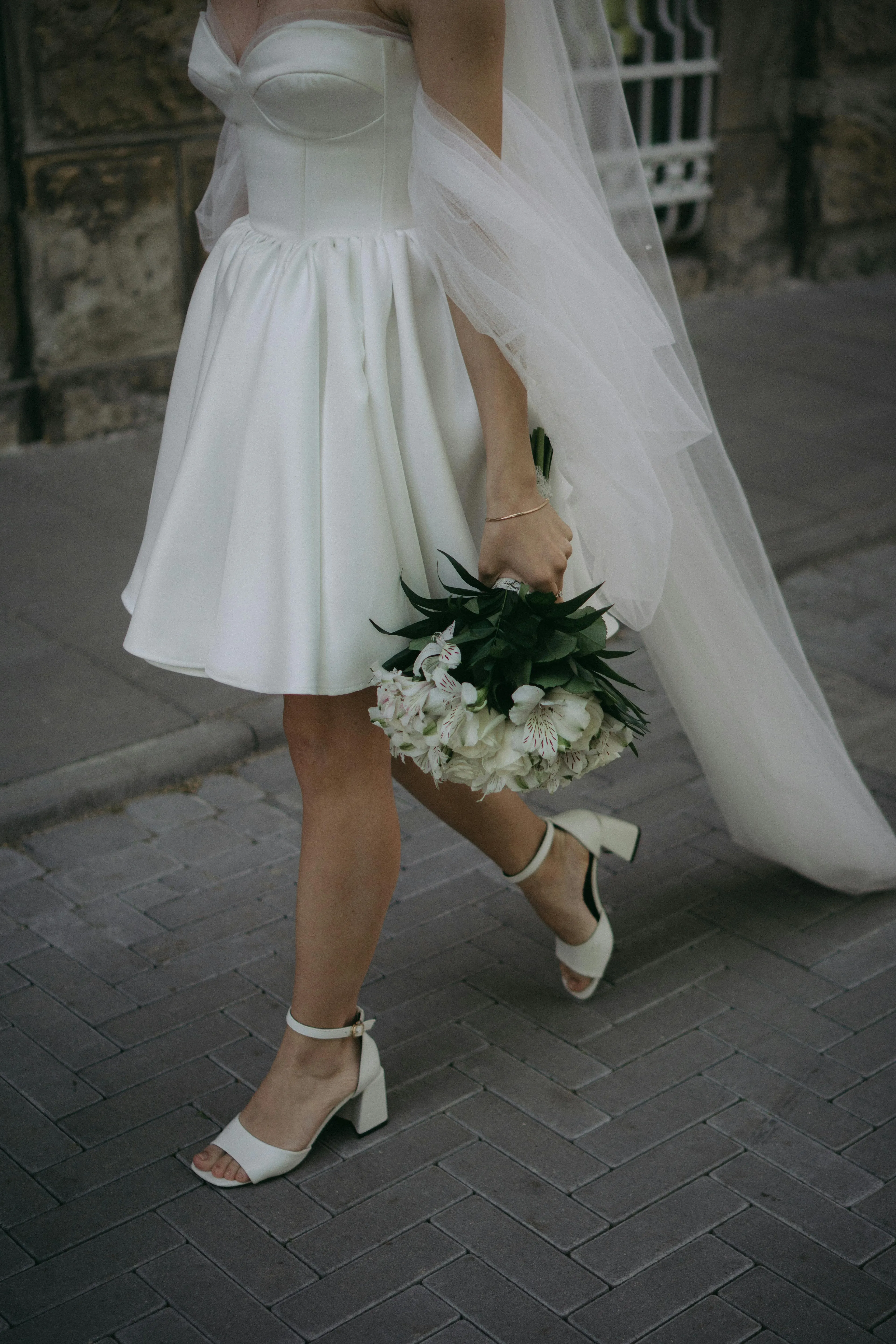 Kristal işlemeli straplez balık gelinlik, Swarovski taş detayları ile gece düğünü için gösterişli tasarım, spot ışık altında parlayan korset ve kuyruk detayı