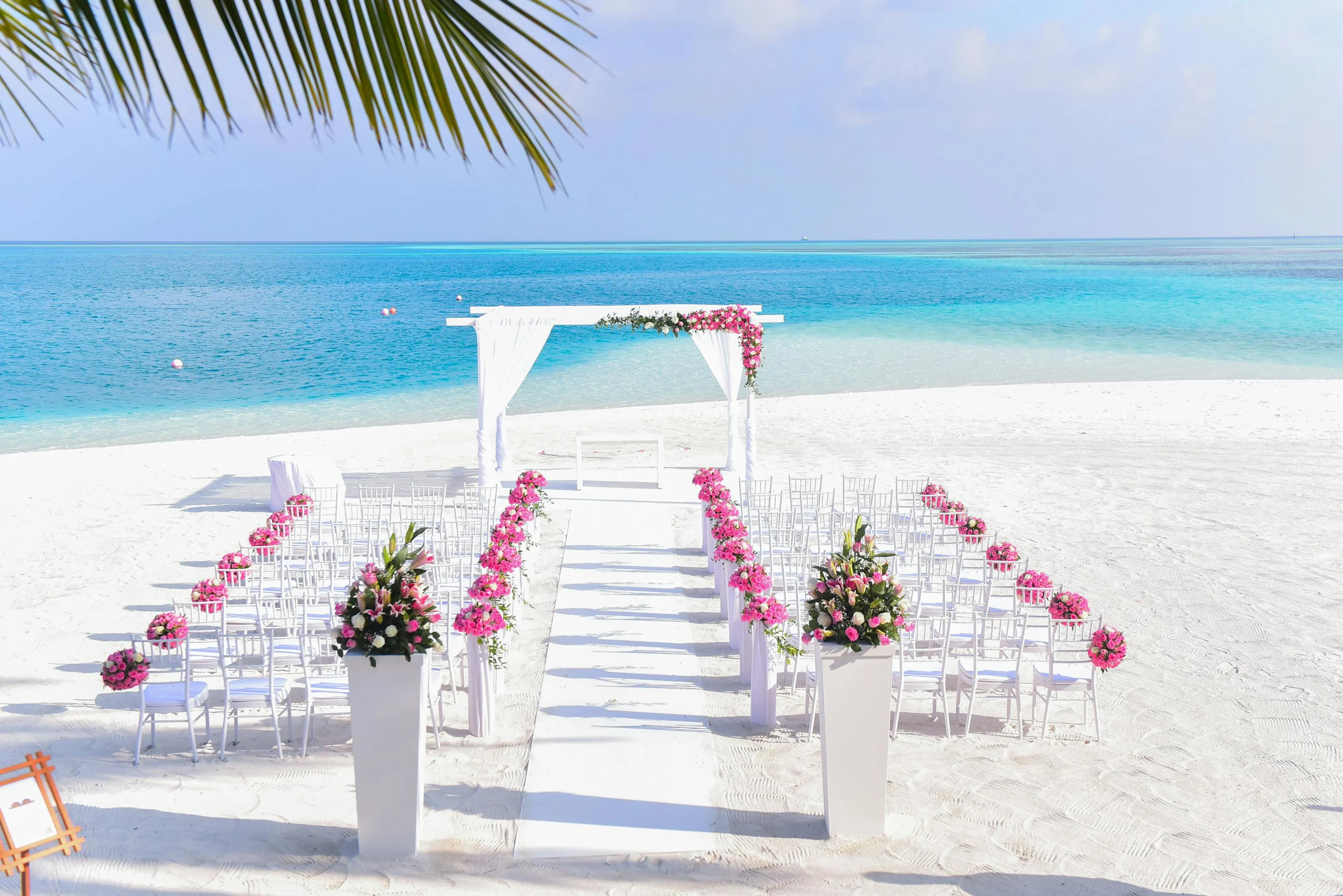 Plaj düğünü lüks konsepti, deniz kenarında beyaz dekorasyon, fenerler, şık masa düzeni, kumda ayaklar ve turkuaz detaylarla romantik atmosfer