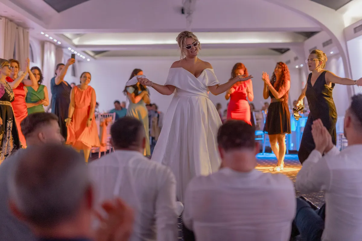 Düğün salonunda gelin ve damadın romantik ilk dansı, yumuşak ışıklandırma ve konukların alkışları eşliğinde unutulmaz anlar, 2026 düğün trendi