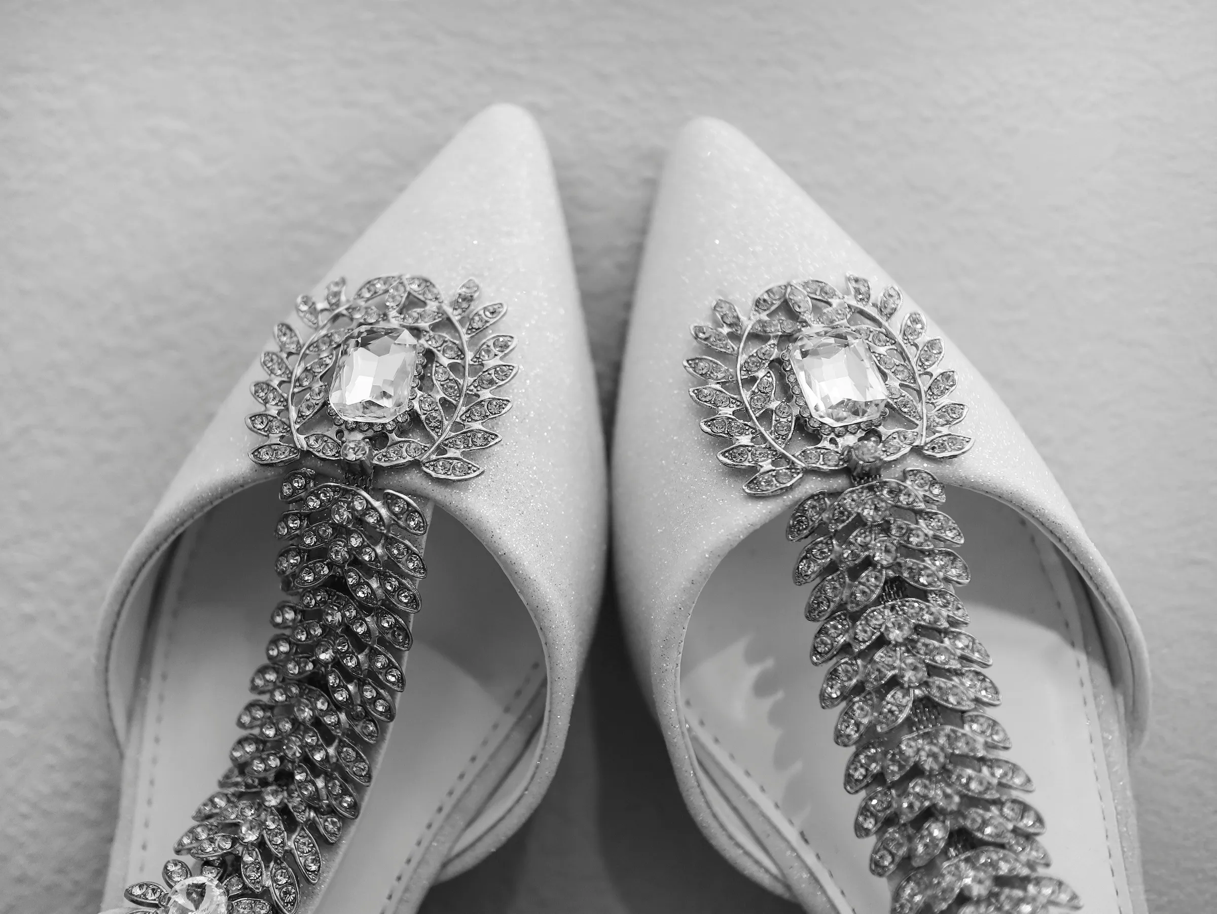 Gelin düğün ayakkabısı giyerken, arkadaşları yardım ediyor, hazırlık anı fotoğrafı, detail shot, düğün sabahı atmosferi, 2026