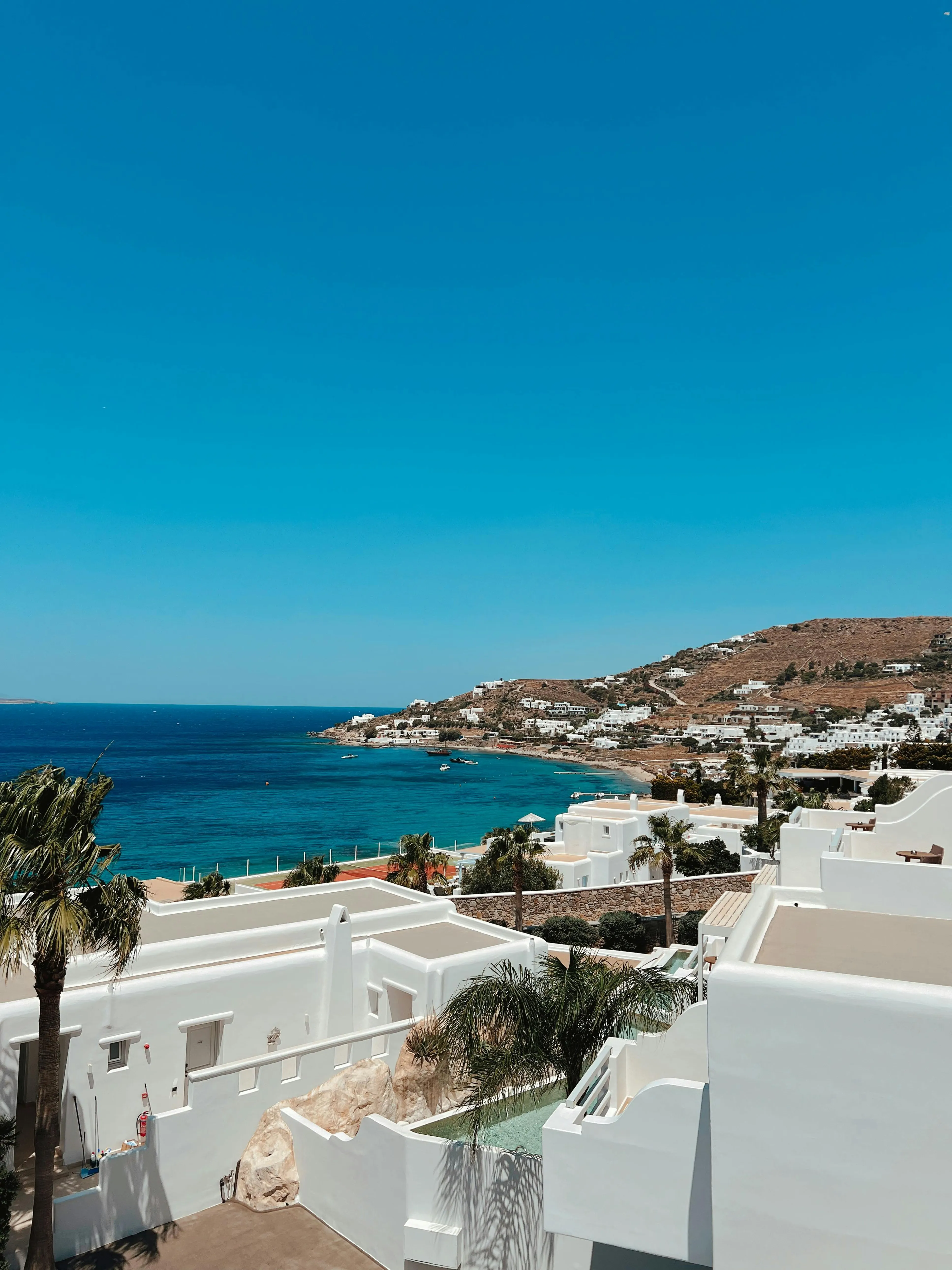 Mykonos plajı, turkuaz deniz, beach club, şemsiye ve şezlong, lüks tatil atmosferi