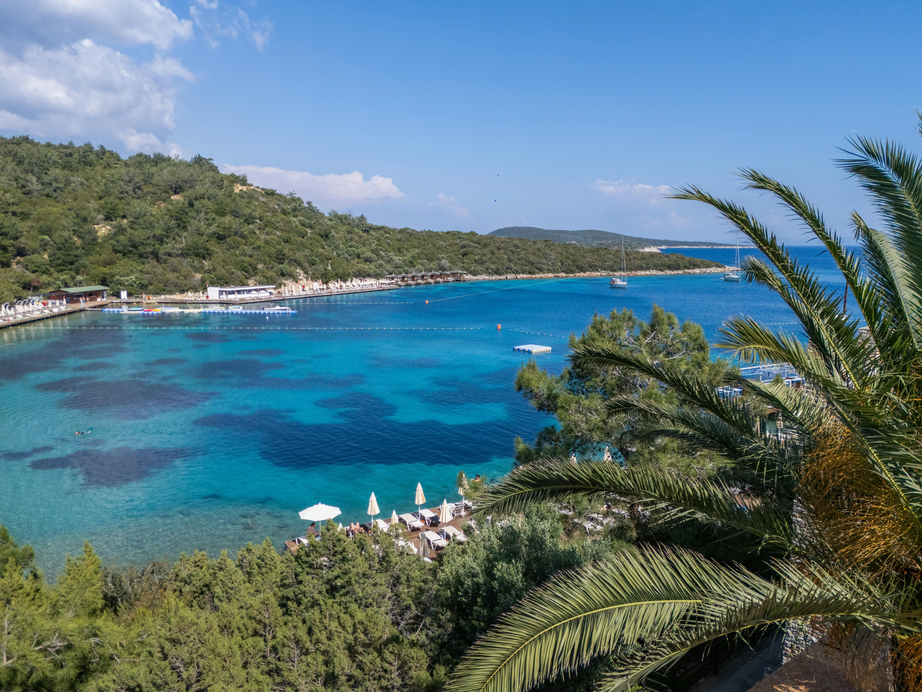 Bodrum sahilinde rustik vintage tarzı kır düğünü, ahşap masa düzenlemeleri ve ampul aydınlatması ile dekore edilmiş açık hava düğün resepsiyonu, deniz kenarı gece çekimi