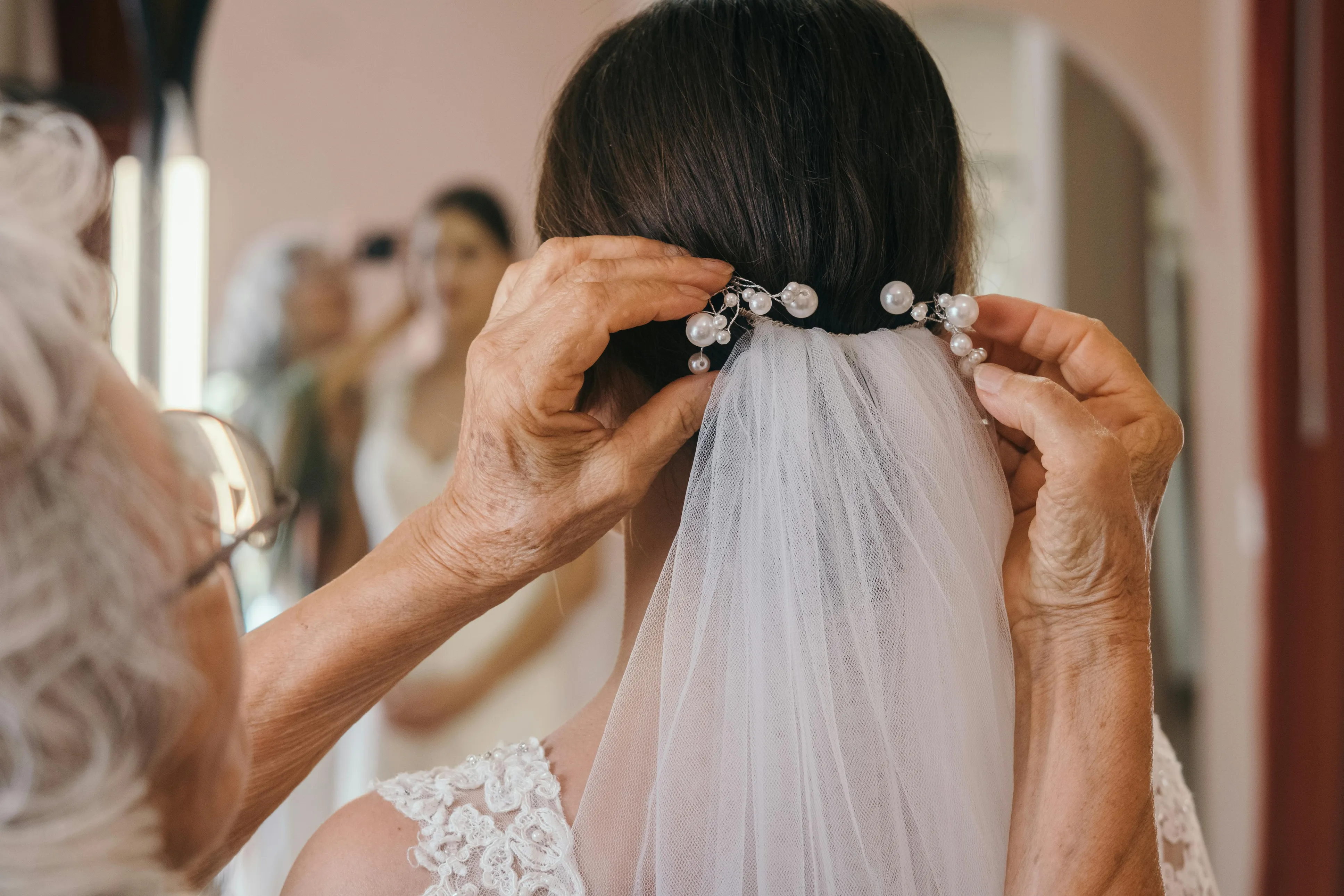 Gelin örtüsü altında yerleştirilmiş kristal taç ve inci tokalar: uzun tül örtüyle uyumlu, klasik gelin saçı detay çekimi